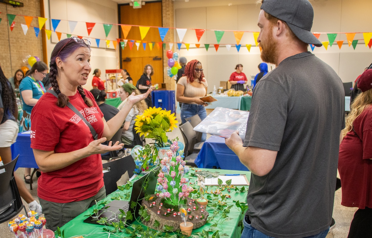 Student development associate Austin McCabe talks to students about NE's Garden Club which is starting back up again after not being active for a couple of years.