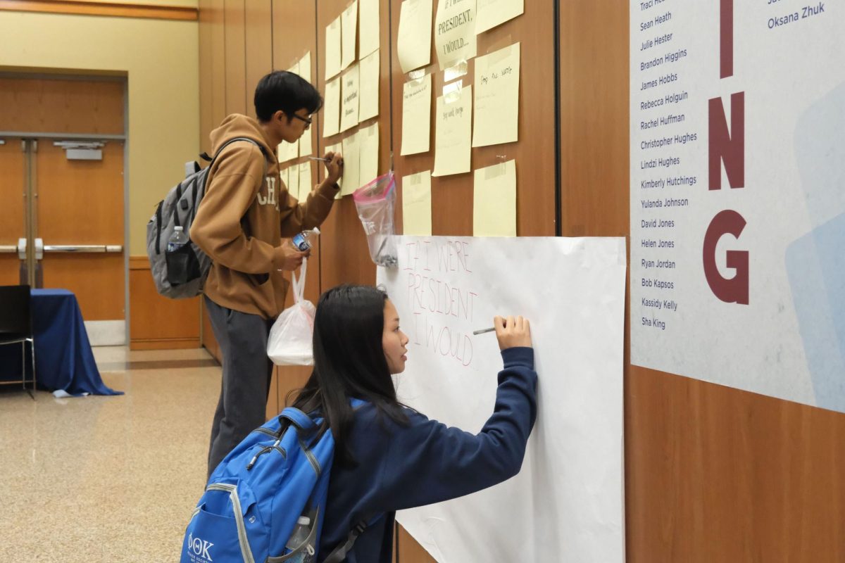 PTK officer Sela Vo and SE student Rafeal Matienzo write on the wall in SE01 Ballroom on SE Campus.