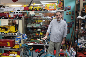 NE art instructor Paul Greco stands behind a vintage Western Flyer bicycle that belonged to his mother when she was young. The bike is displayed in one of his three booths at the Antique Gallery in Denton where he has turned his love for antiques into a side business. Photos by Mario Montalvo/The Collegian