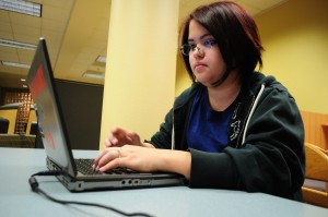 SE student Candy Romero works on her accounting homework with one of the laptops available for checkout in the library. TCC received a state grant to purchase laptops for each campus. Photo by Alice Hale/The Collegian