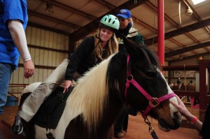 A TR student sits on one of the horses preparing to ride during the visit on Feb. 28.