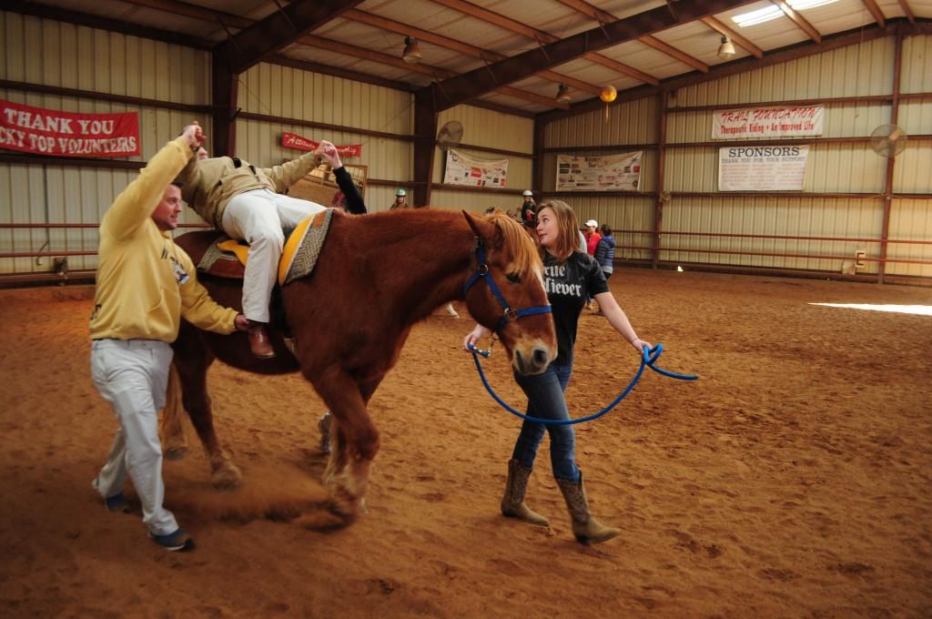 TR student Chris Landry and a Rocky Top Ranch volunteer helped another TR student perform situps, a typical hippotherapy exercise, while riding on the back of a moving horse. 