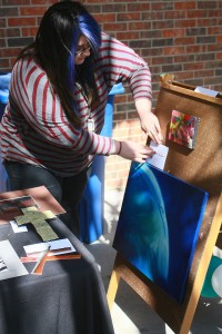 Student artist Viridiana Navarro showcases her painting on the first day of the South Campus Fine Arts Festival March 26. Photo by Carrie Duke / The Collegian