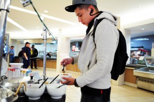 TR student Darin Ramirez customizes his lunch in the Riverfront Cafe located in the TRTR building. Photo by Alice Hale/The Collegian