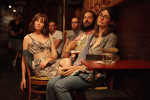 Miranda (Elizabeth Banks), Ned (Paul Rudd) and Liz (Emily Mortimer) watch their sister Natalie (Zooey Deschanel) perform at a comedy club. Ned, the idiot, is the only one laughing. Photo courtesy Weinstein Company