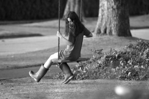Em (Natasha Calis) plays on a swing and stares creepily at the camera in The Possession. This is one of few shots without a creepy door frame. Photo courtesy of Lionsgate