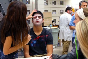 Jackie Barajas adds the finishing touches on Joseph Cristie’s zombie makeup.  Photo by Haylie Jones/The Collegian