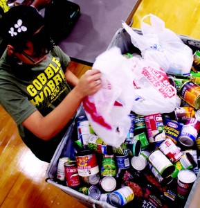 A volunteer collects canned goods to give to the Tarrant Area Food Bank.  Photo by Casey Holder/The Collegian
