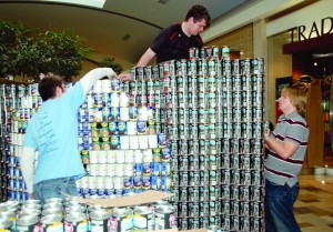 Building a wall against hunger-SE Campus students Charlie Stephens, left, Jeremy Vardaman, center and Thomas Scalfano, right, create sculptures by stacking canned food items in the Tarrant County Canstruction competition at North East Mall Oct. 11.  Photo by Brian Koenig/The Collegian