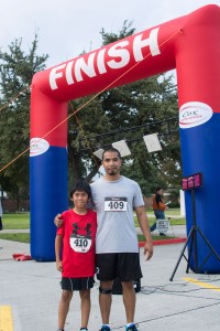 Nine-year-old Aiden Revilla crossed the finish line first, with his father Juan Revilla right behind him.  Photo by Jason Floyd/The Collegian