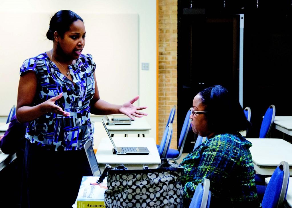 Lusheia Addison, a CMS field enrollment agent, provides information about enrolling in the health insurance marketplace for student Darlene Saulsberry Nov. 15 in NE Campus’ Center Corner. Students received assistance from Centers for Medicare and Medicaid Services representatives on each TCC campus.  Photo by Georgia Phillips/The Collegian