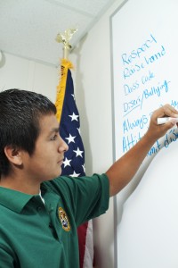 Student P.J. Landa of the introductory class that has been dubbed the Marine Creek Collegiate High School writes on the white board as his classmates call out examples. Photo by Casey Holder/The Collegian