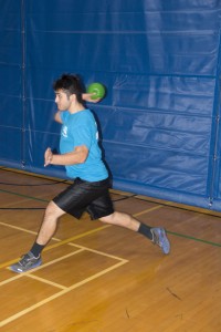 NE student Aamer Qureshi quickly lunges to throw the ball at an opponent. Unlike in the game of dodgeball, players in heroball can stay in the game even after being hit. 