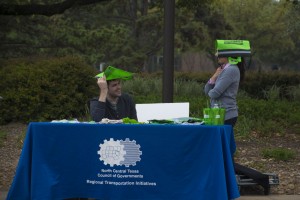 Representatives from North Central Texas Council of Governments have to keep their heads covered when rain interrupts the Spring Fling on South Campus April 17. 