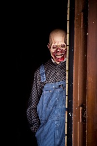 An actor waits to surprise an unsuspecting visitor within Piggy's Blood Shed, one of Six Flags' haunted houses. 