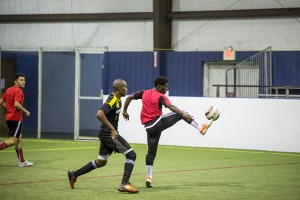 Enock Ntirandekura of Racing Clubs keeps the ball away from the opposing team Dark Ninjas during a South Campus indoor soccer match. The game was tied 4-4 and went to a shootout where Racing Clubs was victorious. Eric Rebosio/The Collegian
