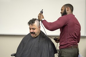 SE Cisco adjunct instructor Julio Casablanca holds up his end of a challenge. With 11 students meeting their end by passing a test, Casablanca agreed to shave his head with the help of one of his students. Photo by Bogdan Sierra Miranda/The Collegian