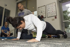 Fitness Center director Nick Giovannitti watches and keeps count of Carmen Garcia’s pushup form during TR’s strength and endurance competition April 17.  Photo by Bogdan Sierra Miranda/The Collegian