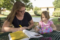 NE student Sarah Williams works in study time while her daughter Braelyn colors. Photo by Katelyn Townsend/The Collegian