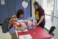 Donna Christy (right) encourages Han Tran to sign up for Student Ambassadors. 