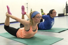 NE student Stephanie Bodenheimer and kickboxing instructor Victoria Babb move into the bow yoga pose after a kickboxing class. Part of the Blue Zone Project requires participants to move more throughout the day. Photo by Katelyn Townsend/The Collegian