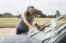 NE student Alexandra Longoria smashes a windshield during a fundraiser sponsored by NE student ambassadors. For $5, students and staff got to take five swings at an old car.Bogdan Sierra Miranda/The Collegian