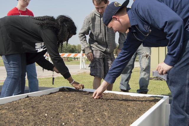 Marc Villanveva, right, assists students in planting the first seedlings of the new garden on SE Campus.
Photo by Christina Feyisetan/The Collegian