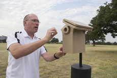 Bird enthusiast and kinesiology associate professor Tim Sebesta tends to a birdhouse.