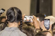 Attendees eagerly work to get good shots of the former president as he took selfies with a few students.