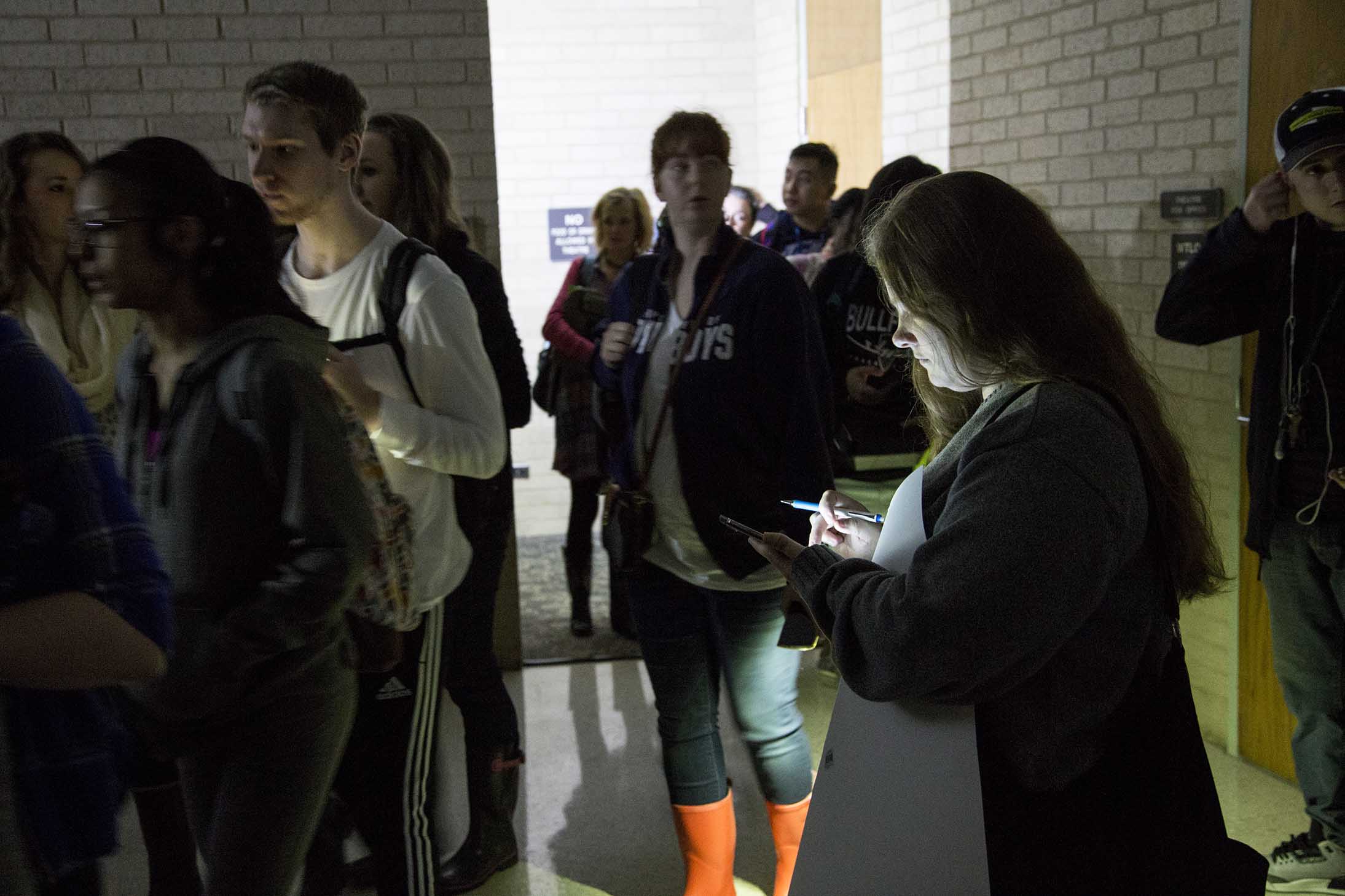 Flashlights and cellphones illuminate the corridors as NW students are escorted to the theater to wait for the storm to pass.