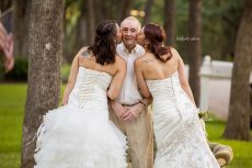 Becca and Sarah Duncan pose for their wedding photo with their father in a neighbor’s front yard. The sisters took the photos so that their father, who suffers from Alzheimer’s disease, could see them in wedding dresses before it was too late.Photo courtesy Lindsey Rabon