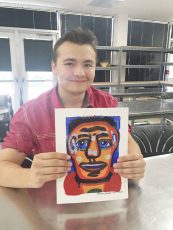 South student Brent Balthrop holds his artwork that he completed last spring. All artwork featured was from an Art Appreciation class.
