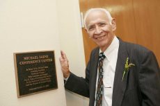 NW founding president Michael Saenz poses next to the plaque outside of the Michael Saenz Conference Center in 2006. Special to The Collegian