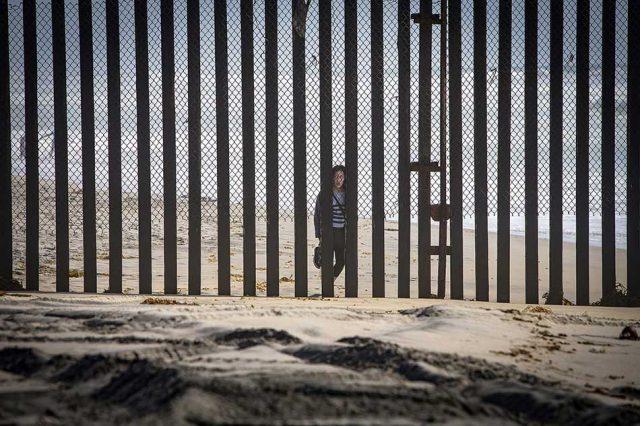 A person peers through the U.S. border fence in Tijuana, Mexico. 

LiPo Ching/Bay Area News Group/TNS