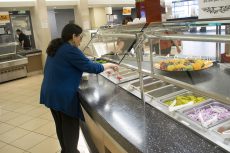 Alumus Angelica Romero puts together her meal by selecting the healthy options offered at the salad and fruit bar at the Riverfront Cafe.