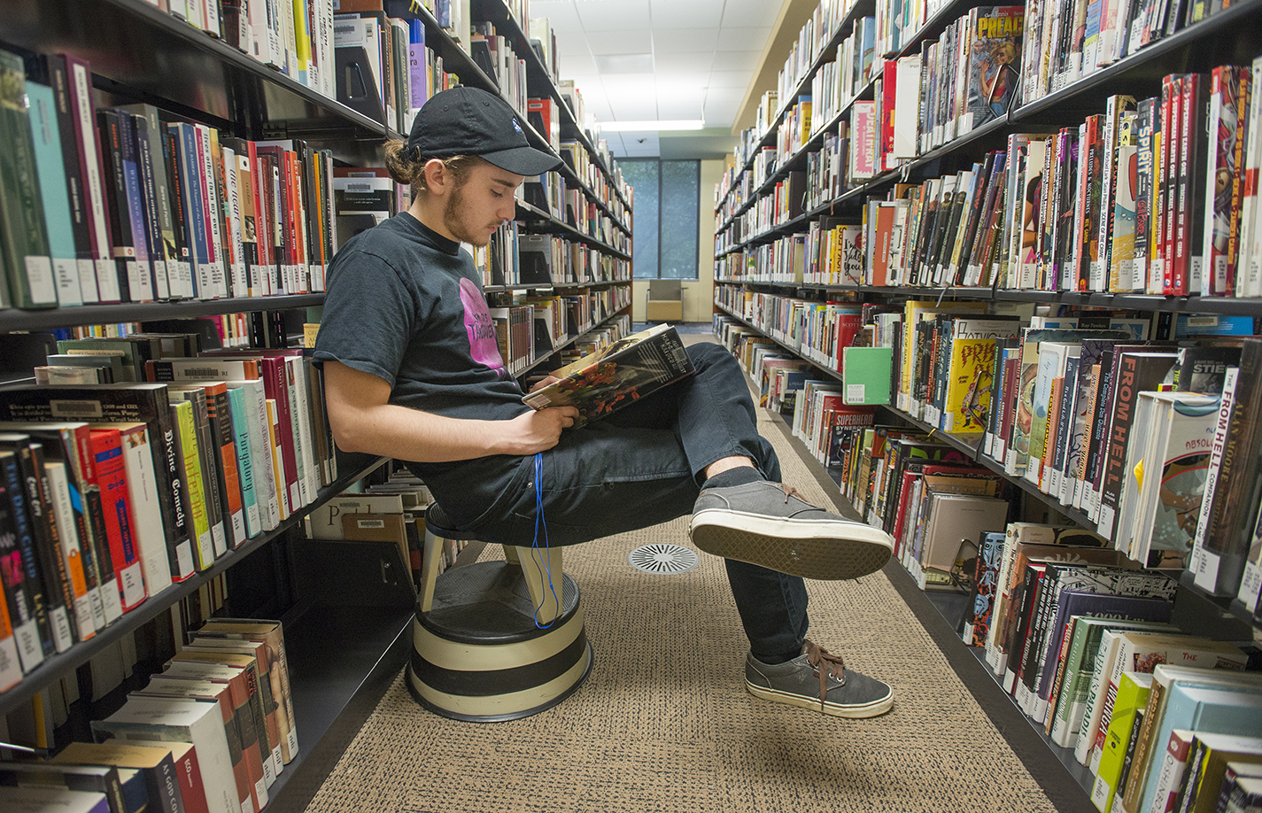 NW student Ashton Hinrjos sits and reads in the TR library while waiting to go to his next class.
