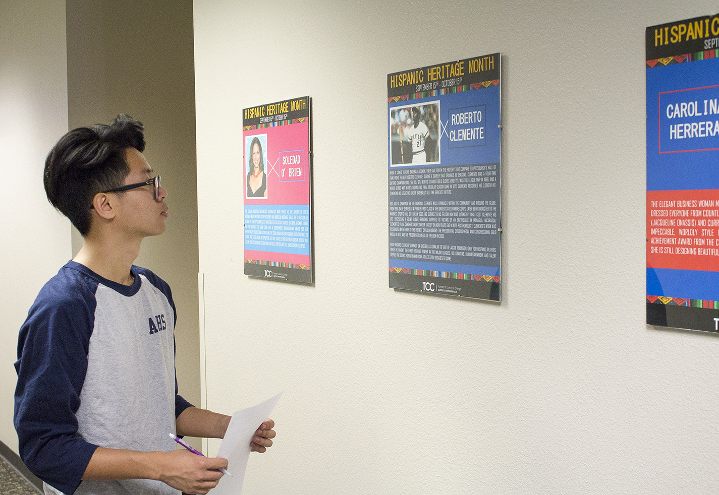 SE student Steven Nguyen looks at a poster featuring Roberto Clemente, an Hispanic baseball player, at the exhibit in Art Corridor III.