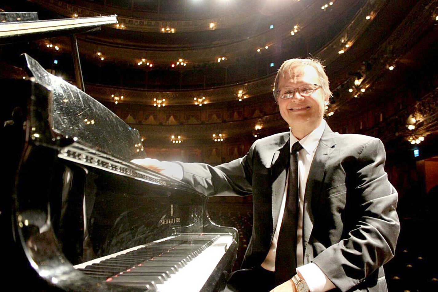 South music professor Oscar Dressler poses with the piano he performed on during a concert in Buenos Aires, Argentina.