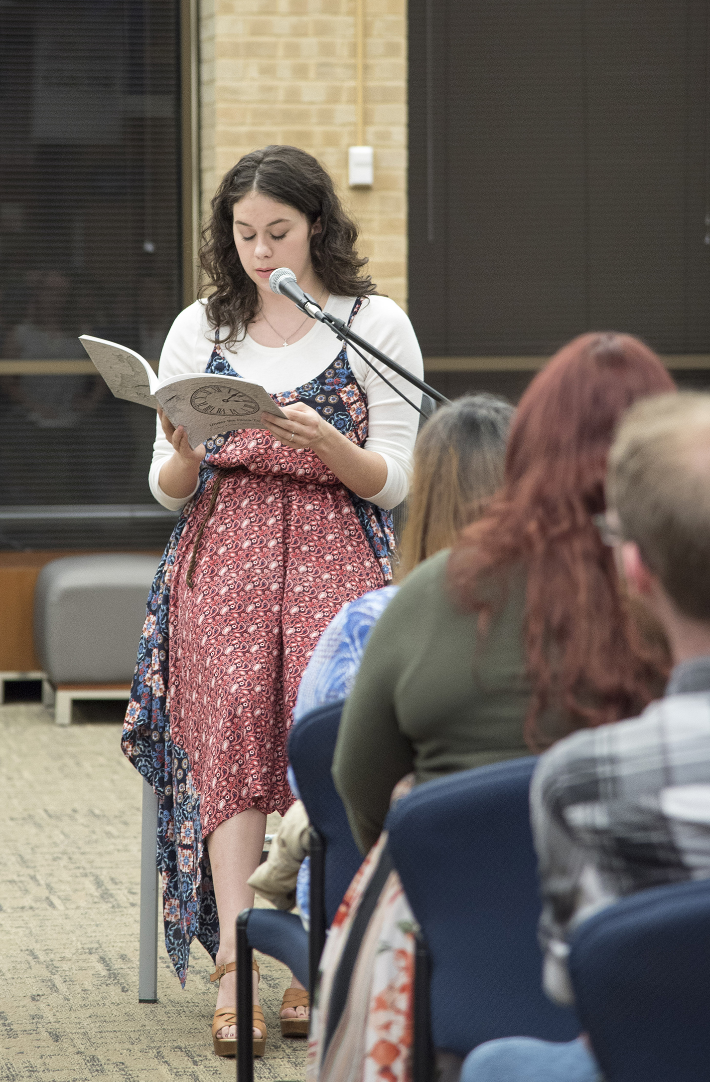 Winner Hannah Daniel reads her poem Four Summers with Ferris which is published in the journal. Right: English associate professor Rebecca Balcarcel introduces contributors during the event.