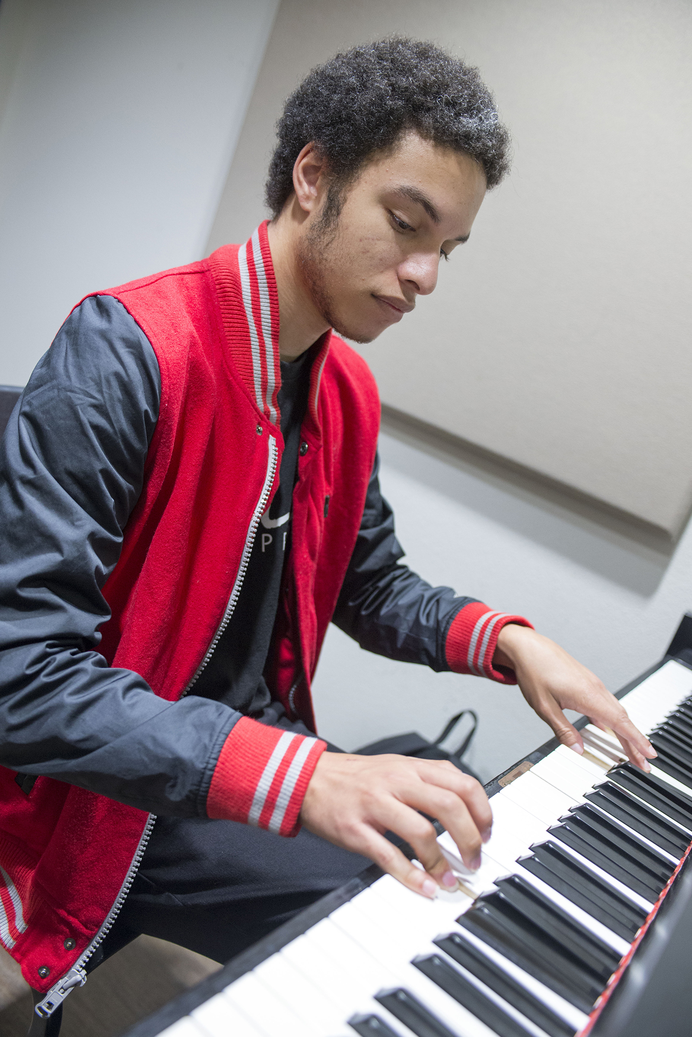 NE student Angel Rivera practices on a piano in a NFAB lab. Advisors encourage students to choose electives that complement their degrees.