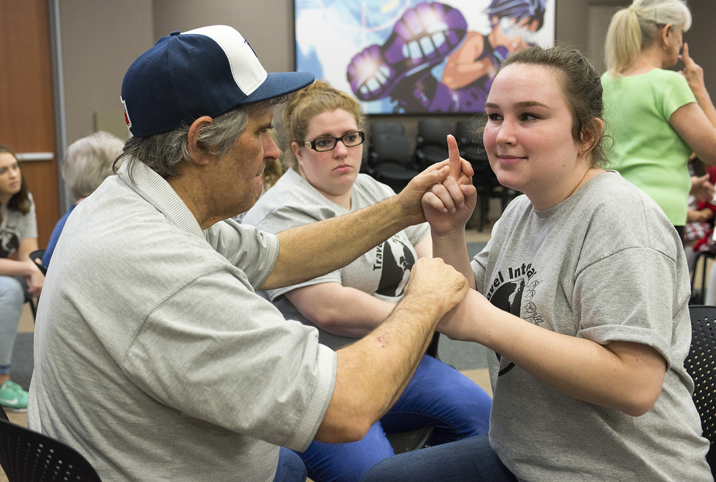TR student Delaney Toone uses her hands to communicate with Glynn Shrods, a deaf and blind man from Fort Worth who shared his story with Deaf, Deaf World attendees.