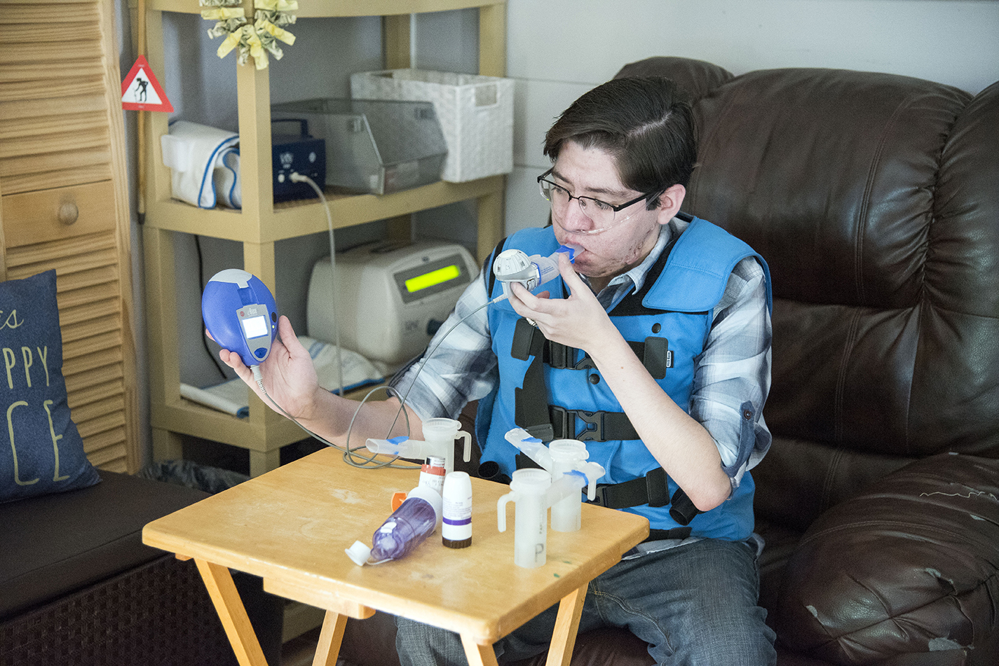 Former NE student Victor Garcia demonstrates how to use one of the machines that administers a medication to help treat his cystic fibrosis.