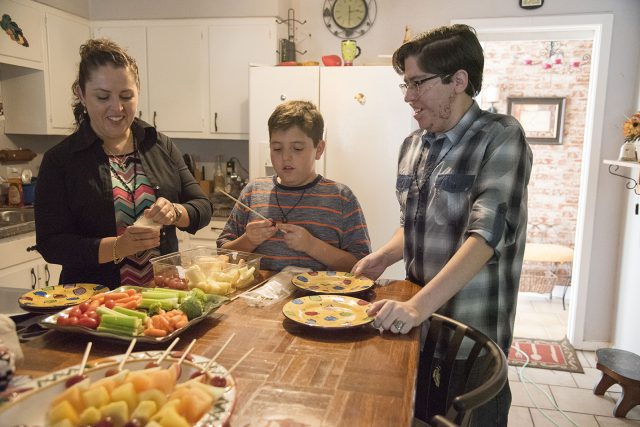 Former NE Campus student Victor Garcia prepares food with his mother, Tere Ramirez, and his little brother, Emmanuel Ramirez at home in their kitchen.