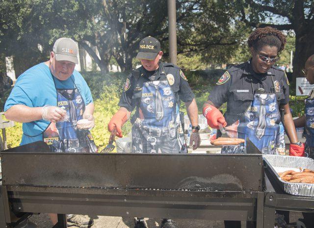 TCC+police+Cpl.+David+Luttrell%2C+Lt.+Greg+Bowen+and+Officer+Teresa+Benson+cook+hot+dogs+and+hamburgers+for+students+during+the+annual+Cookout+with+the+Cops+on+South+Campus+Oct.+5.