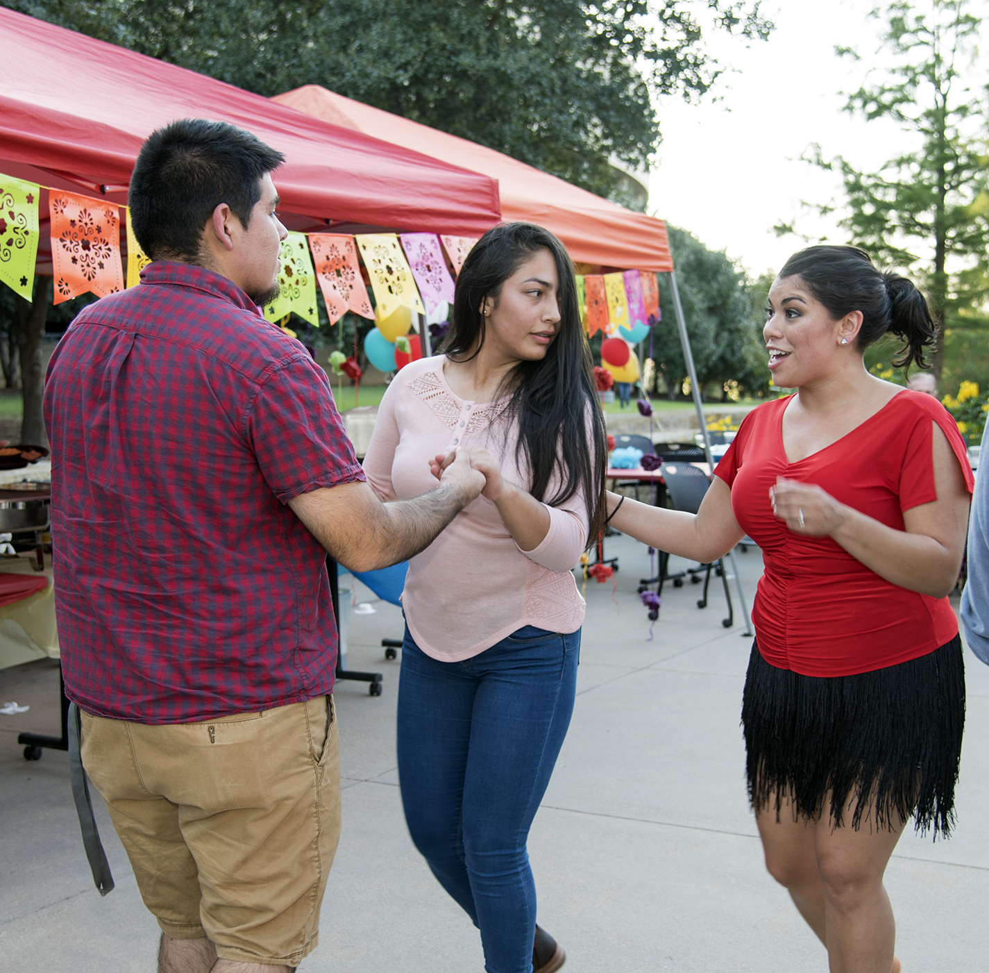 Stephanie Rivera helps TR students Adrian Jaure and Marcela Brochere learn the moves of salsa dancing during ¡Noche de Salsa! on the TR Plaza Oct. 12.