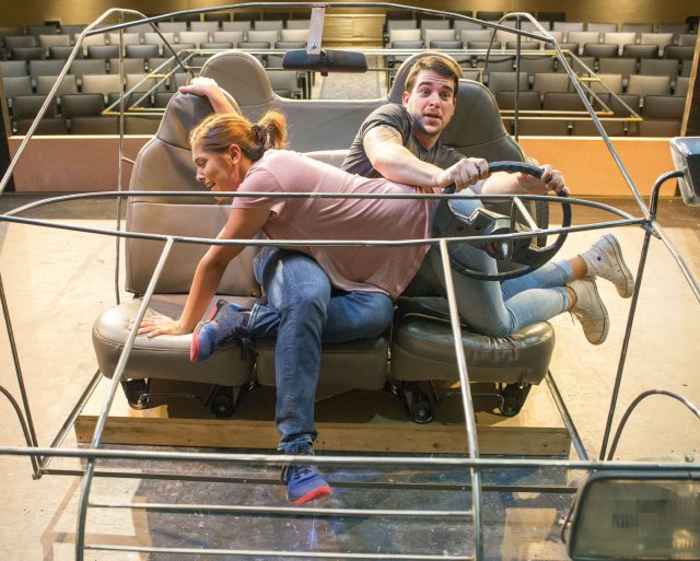 NW student Brian Johnson takes the wheel as NW student Jesse Martinez climbs to the passenger seat. Johnson plays five different characters in the production.