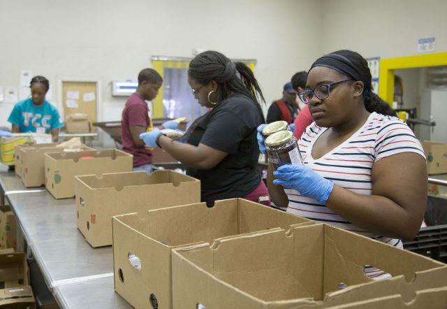 South students Latricia Douglas and Jasmine Carey help package and sort food items Nov. 17 to be delivered to food pantries around Tarrant County. They volunteered through the Students Targeting and Reaching Success program.