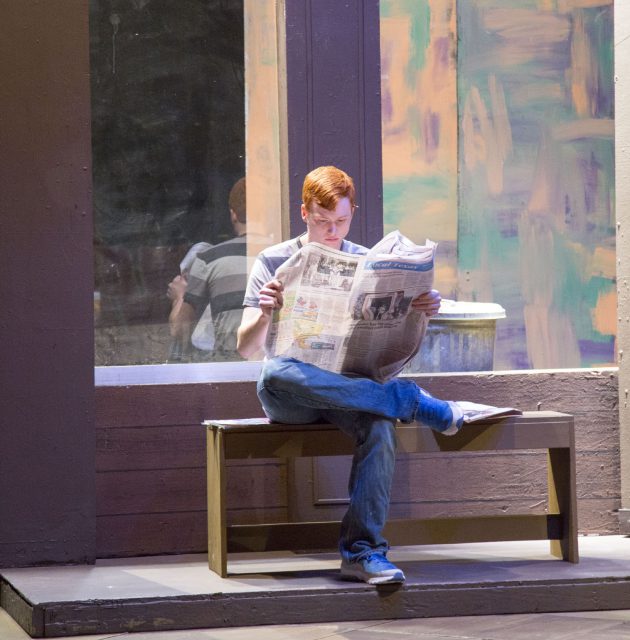 South student Christian West, who plays three characters including Frank reads a newspaper during a rehearsal Oct. 31. 