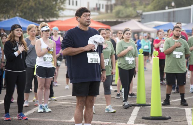 Hundreds of runners gather for the national anthem before the Toro Dash races kick off at Panther Island Nov. 4. The annual event raises money for the Student Wellness Scholarship fund.