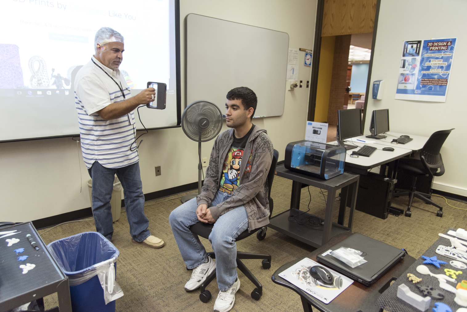 Computer aided drafting adjunct instructor Jeff Opel scans NE student and 3-D Makers club president Conner Reyes’ face to demonstrate how to take a 3-D selfie.